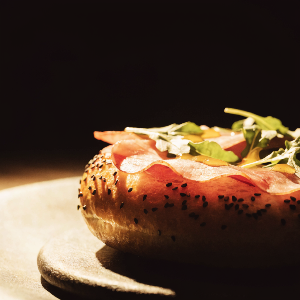 Gourmet bagel sandwich stacked high on dark stone